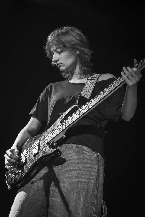 Bassist playing under stage lights